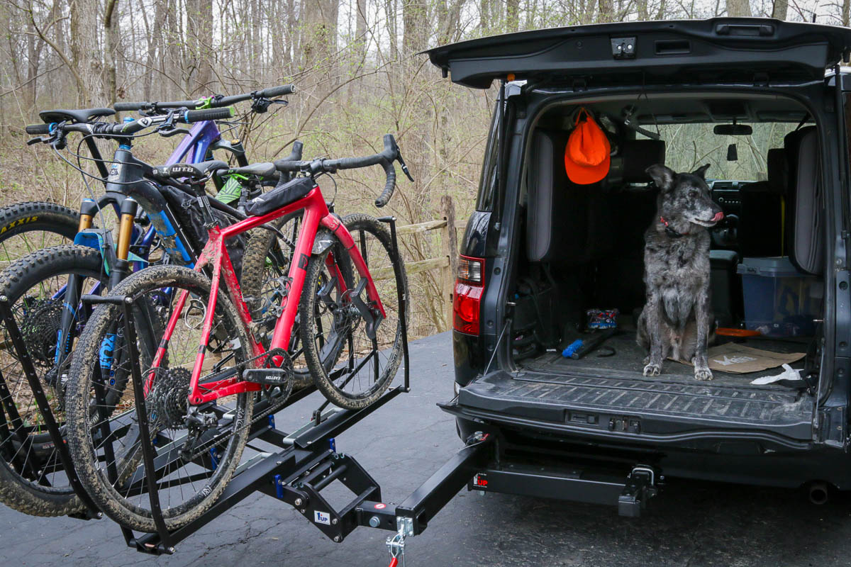 A rack with a swing-away feature to allow access to the rear of the vehicle